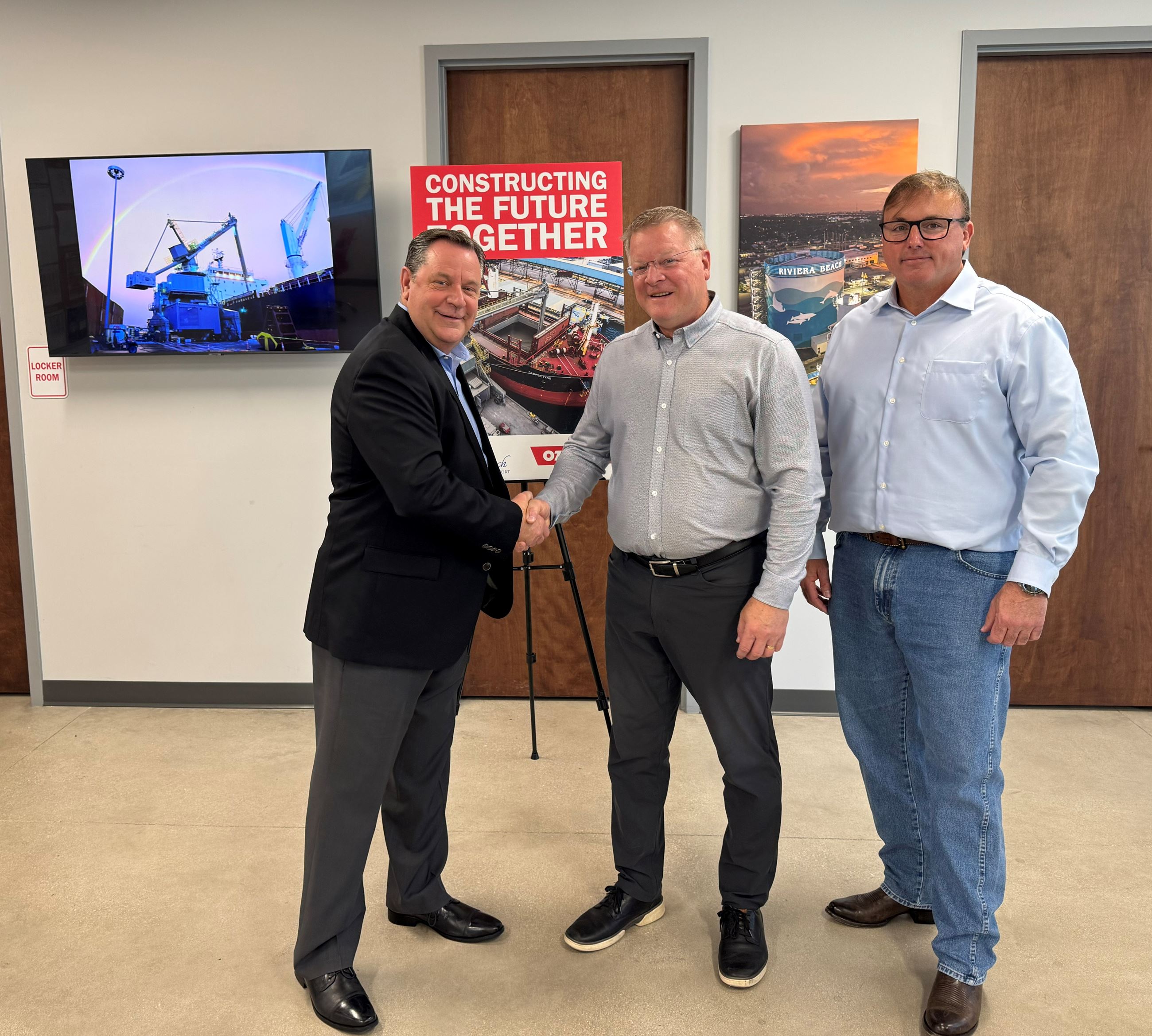 Port Executive Director Michael Meekins shaking hands with Ozingas VP of Strategic Development Greg 