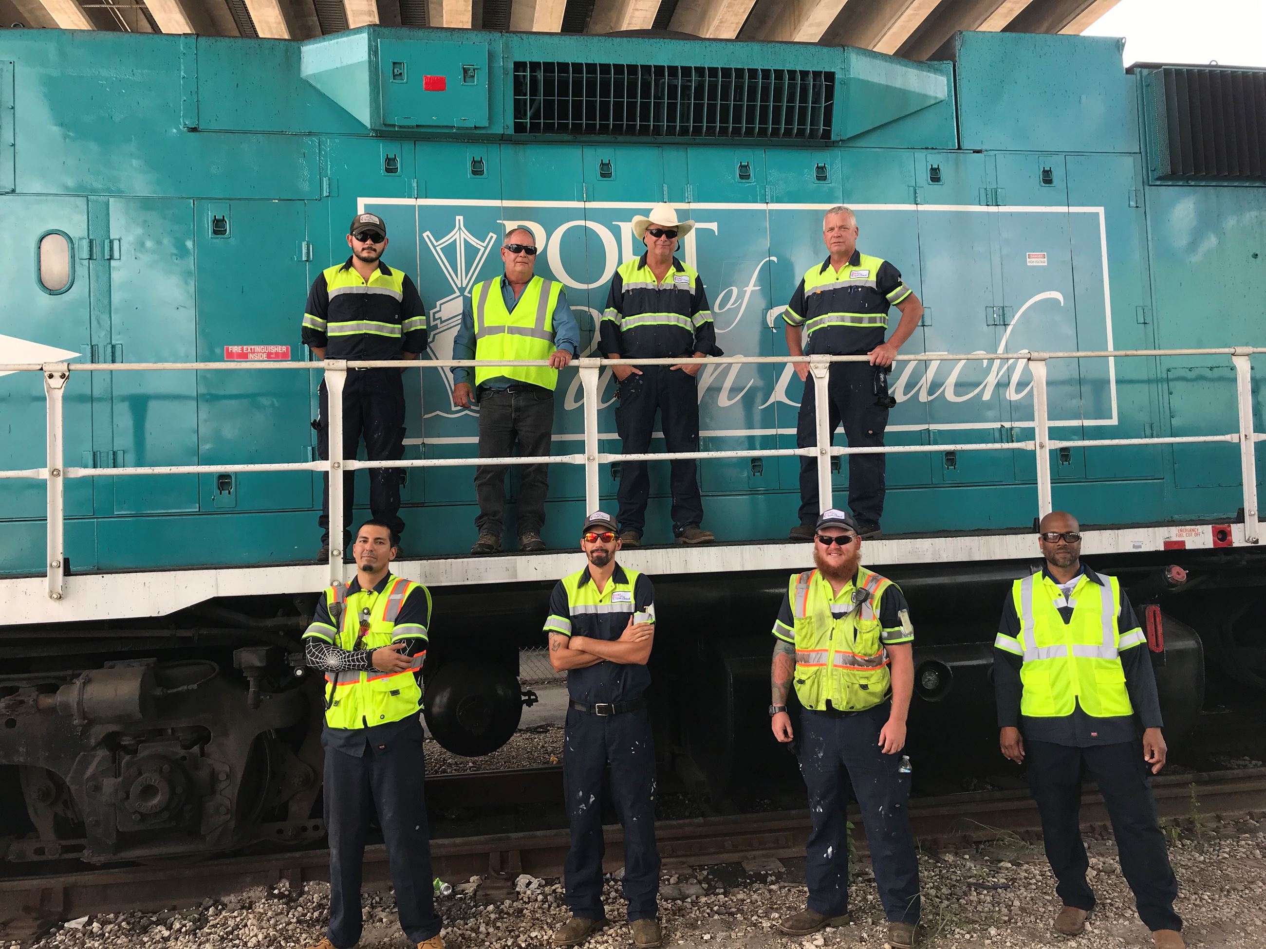 Rail team posing in front of locomotive