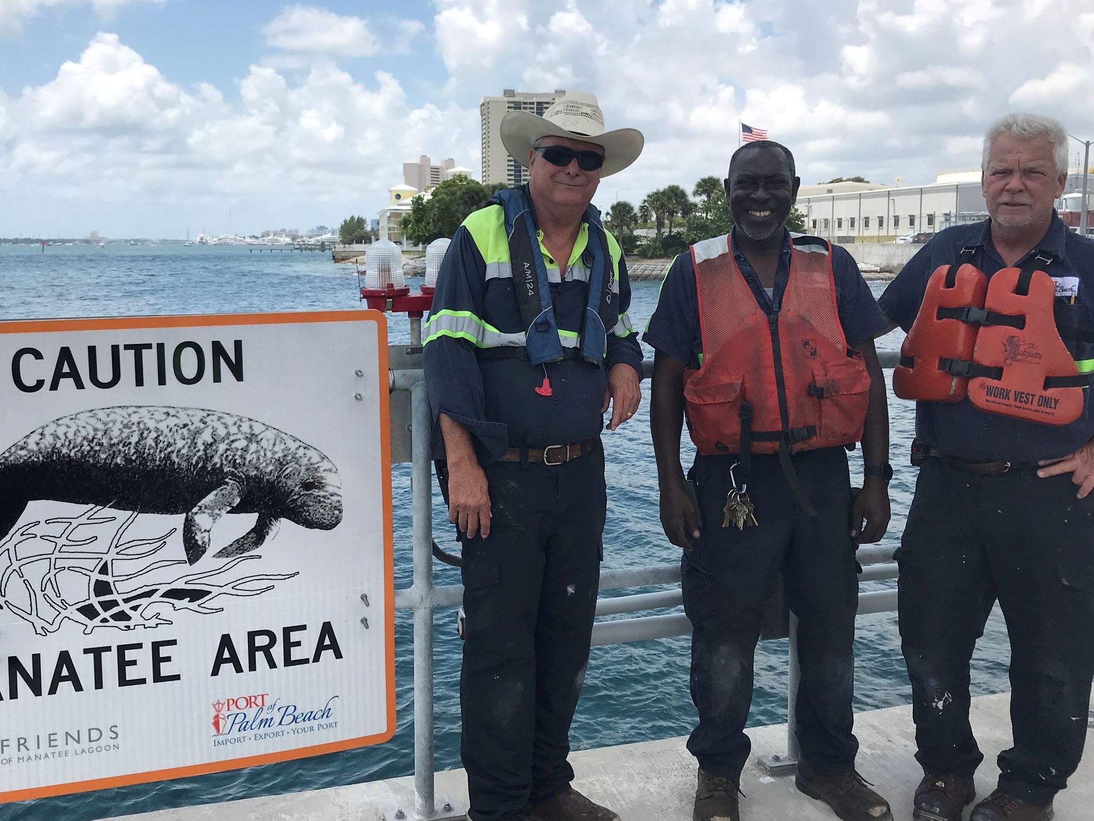 Port facility workers install caution manatee area signs
